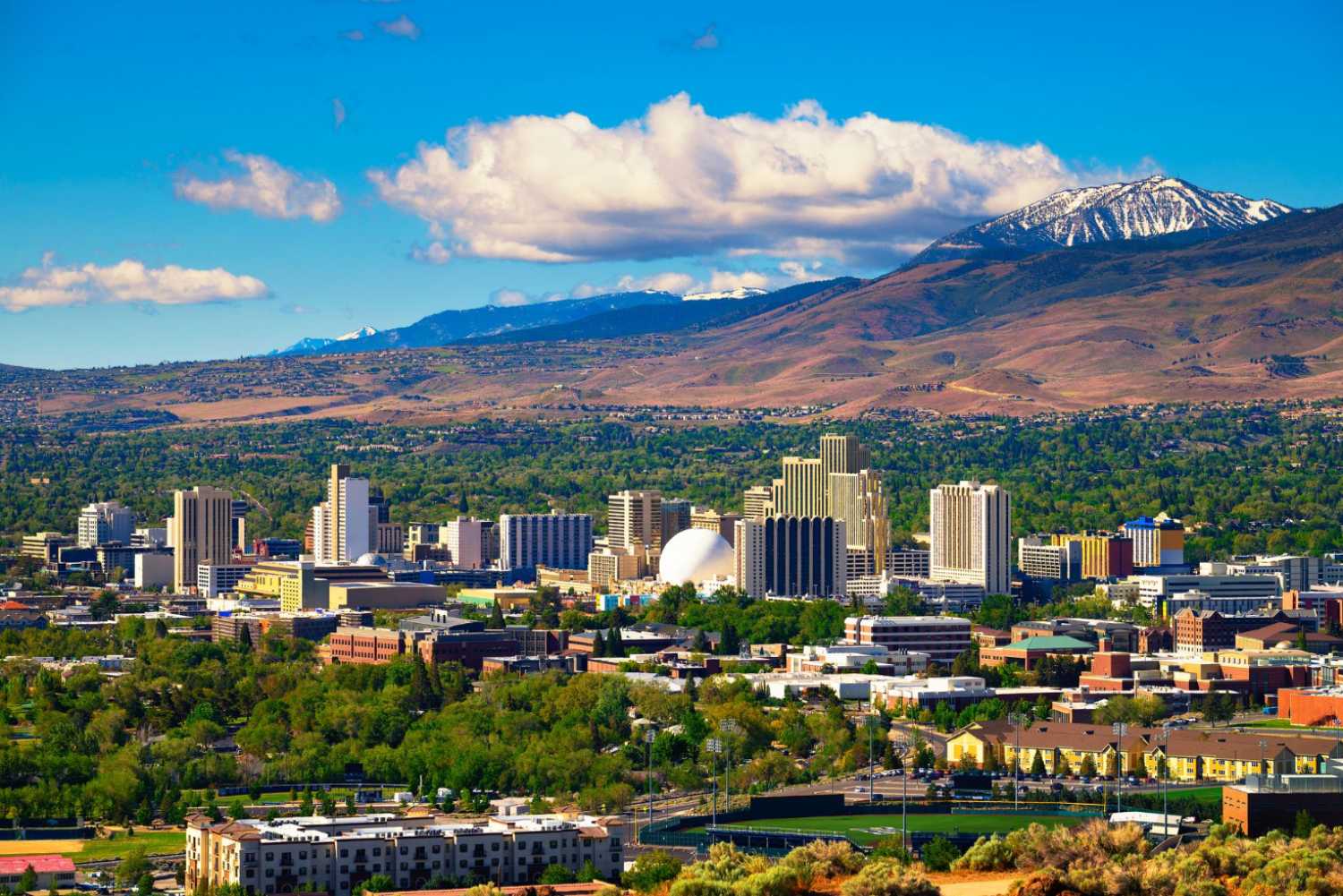 Downtown reno skyline nevada with hotels casinos and surrounding mountains